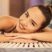 A happy woman with a bun relaxing and smiling at an indoor poolside, creating a warm and inviting atmosphere.